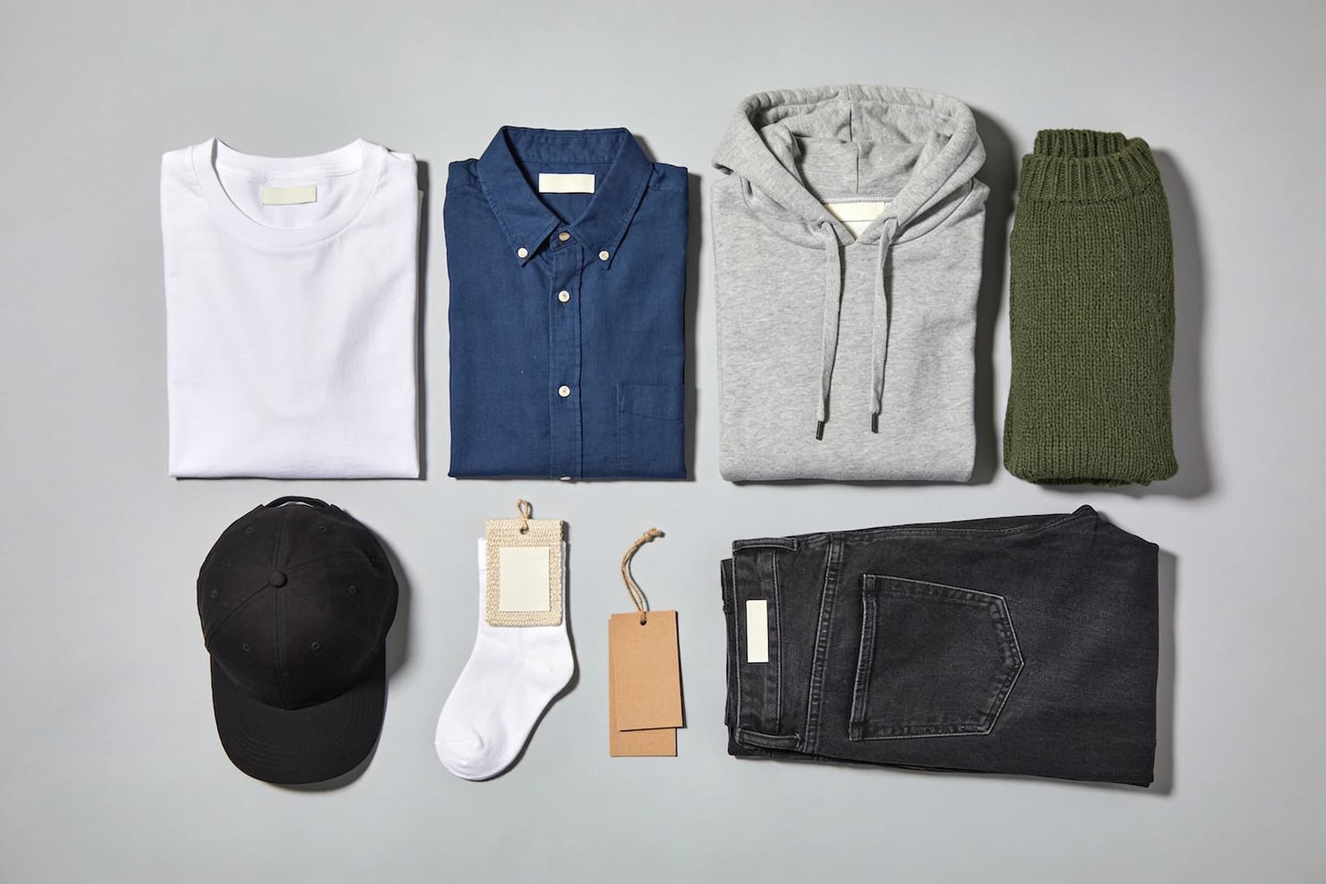 Folded t-shirt, shirt, hoodie, sweater, jeans, cap and socks with blank labels and hangtags